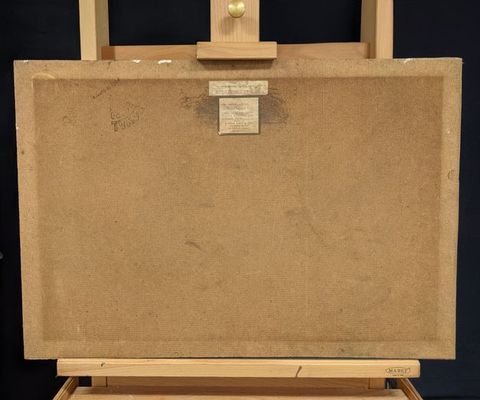 Colour photograph. An artwork is seen resting backwards on an easel, documented against a black background. Two small labels are attached to the artwork, along with a black ink stamp mark in a triangular shape, with the word ‘Royal’ just visible. Traces of white paint are just visible on the upper part of the outer frame.