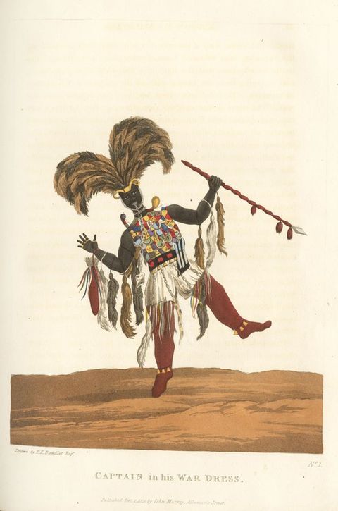 Drawing. A colour drawing of a black man wearing colourful and flamboyant clothing, including an elaborate feather headdress, a vibrant patchwork vest, and a series of feathered arm adornments. He leans to one side as if caught mid-dance, and holds a long, red spear with a spike tip in one hand. Below the drawing is the text, ‘Captain in his War Dress.’
